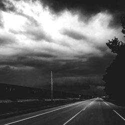 Empty road against cloudy sky