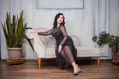 Young woman sitting on chair at home