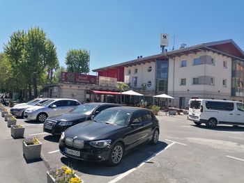 Cars on road by buildings against clear sky