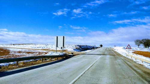 Road in winter against blue sky