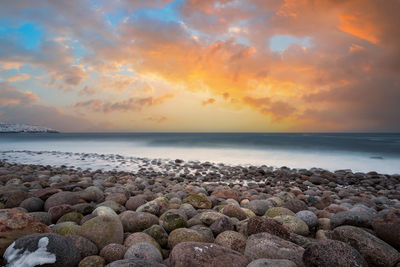 Long exposure of the surf breaking on an arctic boulder beach on the barents sea,  at sunset