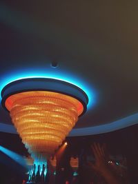 Low angle view of illuminated carousel against sky at night