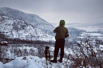 Woman standing on snow covered mountain