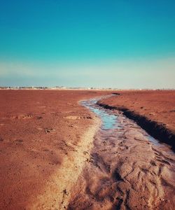 Scenic view of desert against clear blue sky