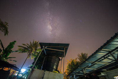 Low angle view of illuminated trees against sky at night