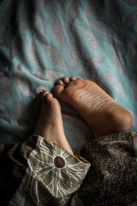 Low section of woman lying on bed