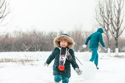 Cute boy playing on snow covered land