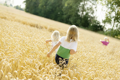 Children walking through wheat field