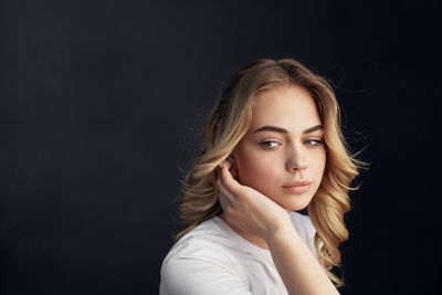 Portrait of a beautiful young woman over black background