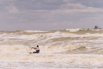 Man standing on sea shore against sky