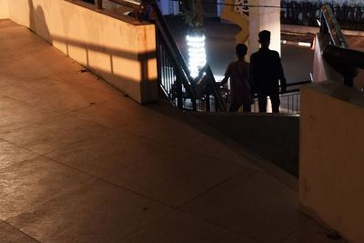 Rear view of people walking on tiled floor