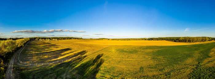 Aerial view of agricultural field against blue sky