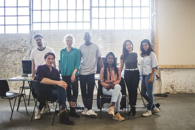 Portrait of confident young programmer's team at creative office