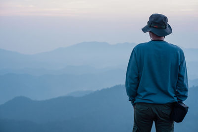 Rear view of man standing against mountain