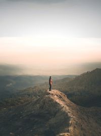 Man on mountain against sky during sunset