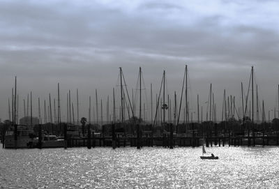 Sailboats moored in sea against sky