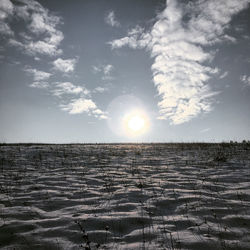 Scenic view of landscape against bright sun