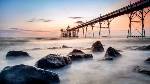 Pier on sea at sunset