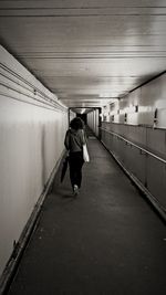 Rear view of woman walking in tunnel