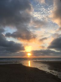 Scenic view of sea against dramatic sky during sunset