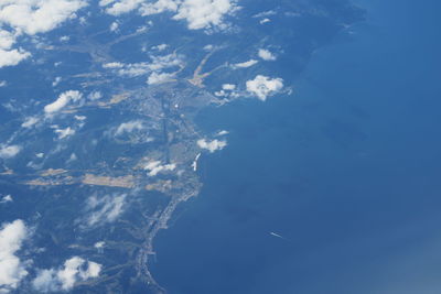 Low angle view of aerial view of sea and mountains against blue sky