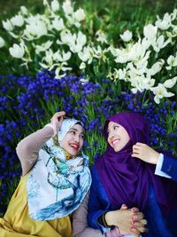 High angle view of cheerful female friends lying on flowers