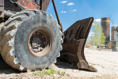 Close-up of machinery on field against sky