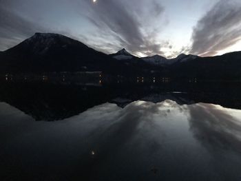 Scenic view of lake by mountains against sky