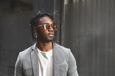 Fashionable young man looking away in city