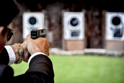 Close-up of man aiming gun during target shooting