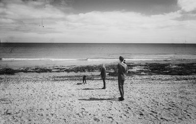 Siblings standing with dog at towan beach