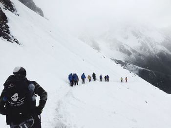 Rear view of people on snow covered landscape