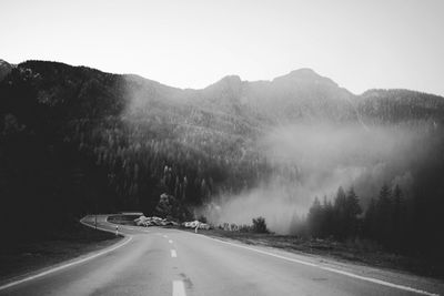 Road by mountains against sky