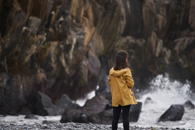 Rear view of woman standing at beach