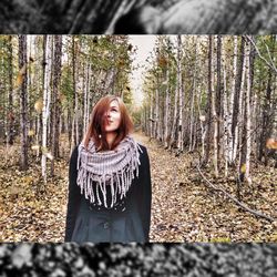 Portrait of smiling young woman standing in forest