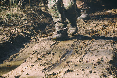 Low section of army soldiers standing on mud