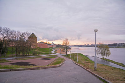 Street by river against sky in city