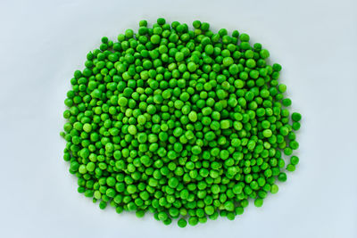 Directly above shot of green peas against white background