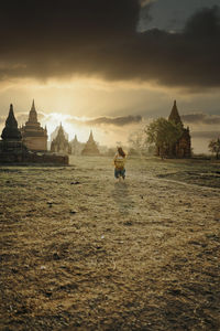 Panoramic view of temple and building against sky during sunset