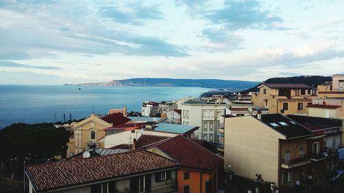 High angle view of houses by sea against sky