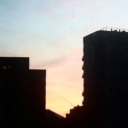 Silhouette of buildings against sky at sunset