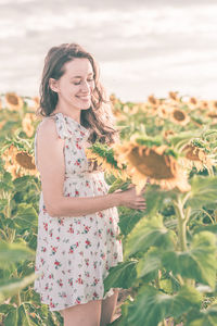 Woman standing by flower on field