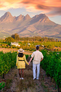 Rear view of couple walking on mountain