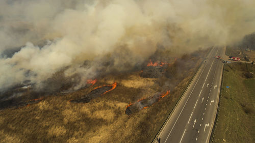 Massive fire, dry grass lanes in fire, firefighters at work, disaster, ecological catastrophe