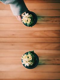 High angle view of person holding drink on wooden table