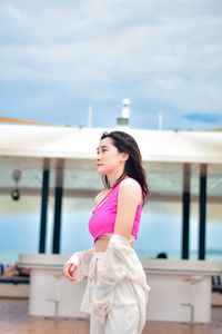 Portrait of young woman standing in city