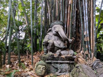Statue by trees in forest
