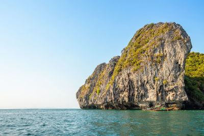 Scenic view of rock formation in sea against clear sky