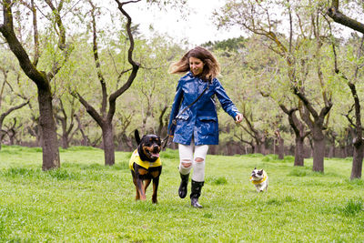 Happy woman with dogs running in public park