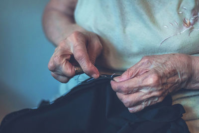 Midsection of woman sewing textile